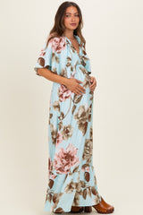 woman wearing a light blue floral maternity dress with ruffled hem and holding her baby bump