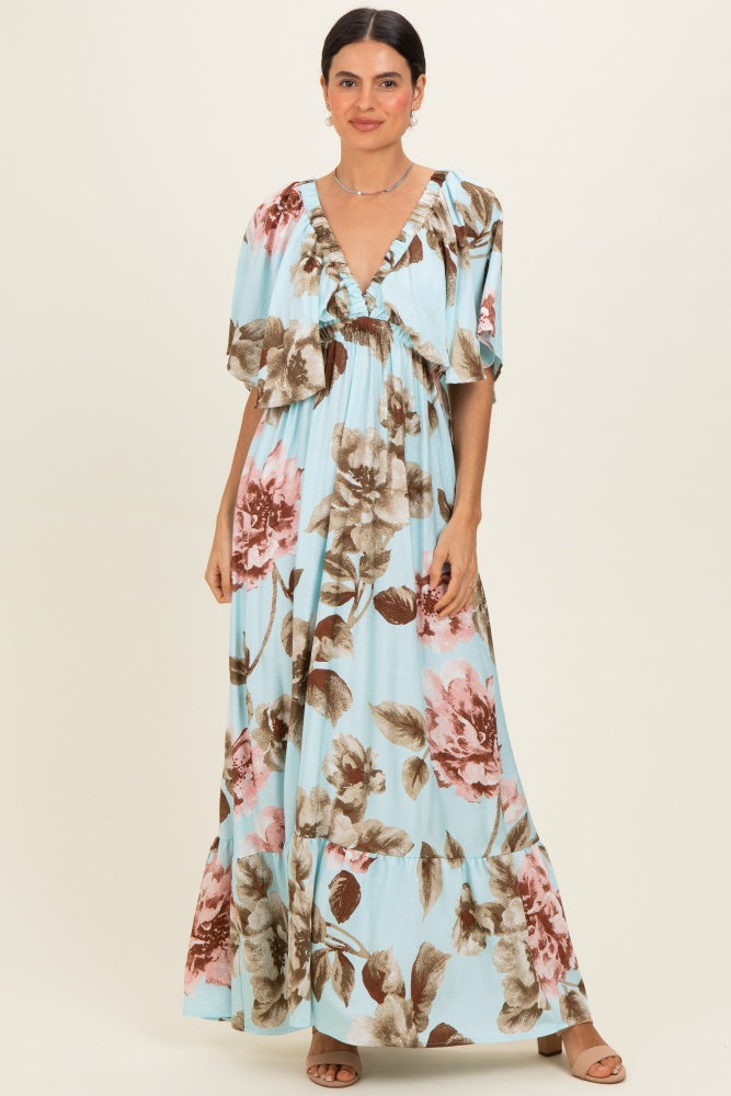 woman wearing a light blue maxi dress with floral print and flutter sleeves