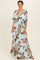 woman wearing a light blue maxi dress with floral print and flutter sleeves