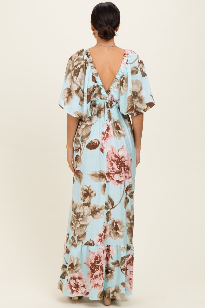 woman wearing a light blue floral maxi dress with a deep v-back and flutter sleeves