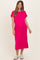 woman wearing a bright pink maternity dress with short sleeves and a pocket, smiling and showing her baby bump