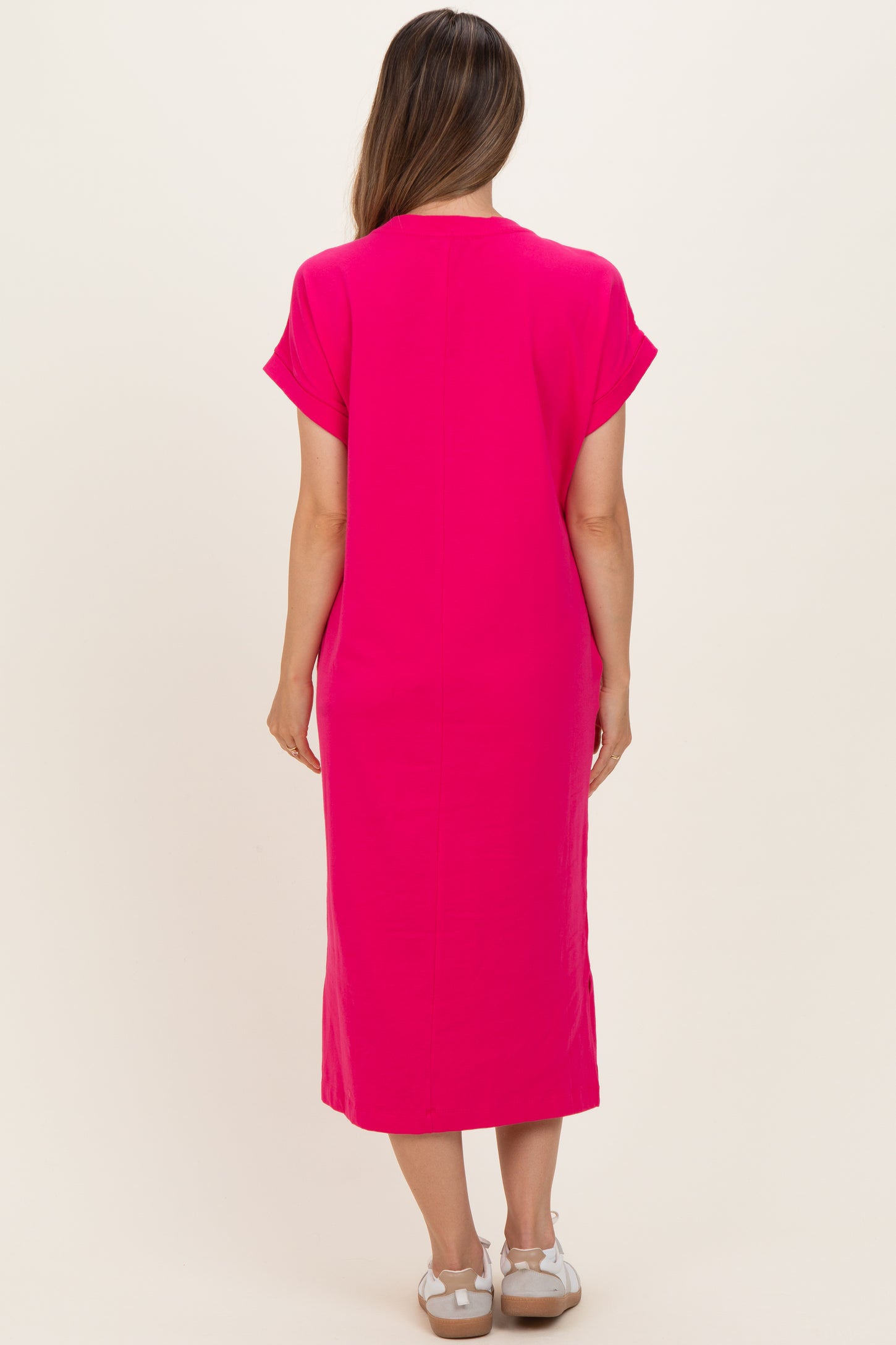 woman wearing a bright pink maternity dress with short sleeves and a relaxed fit, showing no baby bump