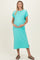 woman wearing a teal maternity dress with short sleeves and a side slit, cradling her baby bump
