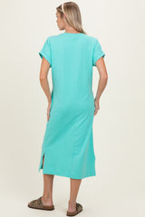 woman wearing a mint green maternity dress with short sleeves and side slits, seen from the back