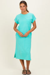 woman wearing a turquoise short sleeve midi dress with a pocket and side slits