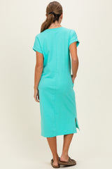 woman wearing a teal short sleeve midi dress with side slits, viewed from the back