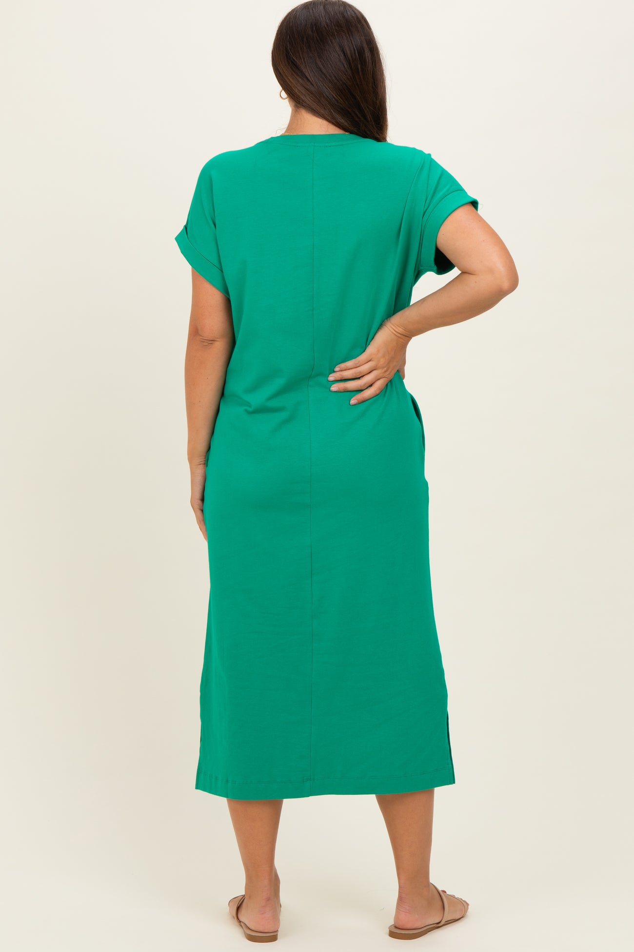 woman wearing a green maternity dress with short sleeves and a relaxed fit, showing off a baby bump from behind