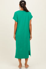 woman wearing a green midi dress with short sleeves and side slits, viewed from the back