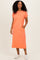 woman wearing an orange short sleeve t-shirt dress with a pocket and side pockets, standing and smiling