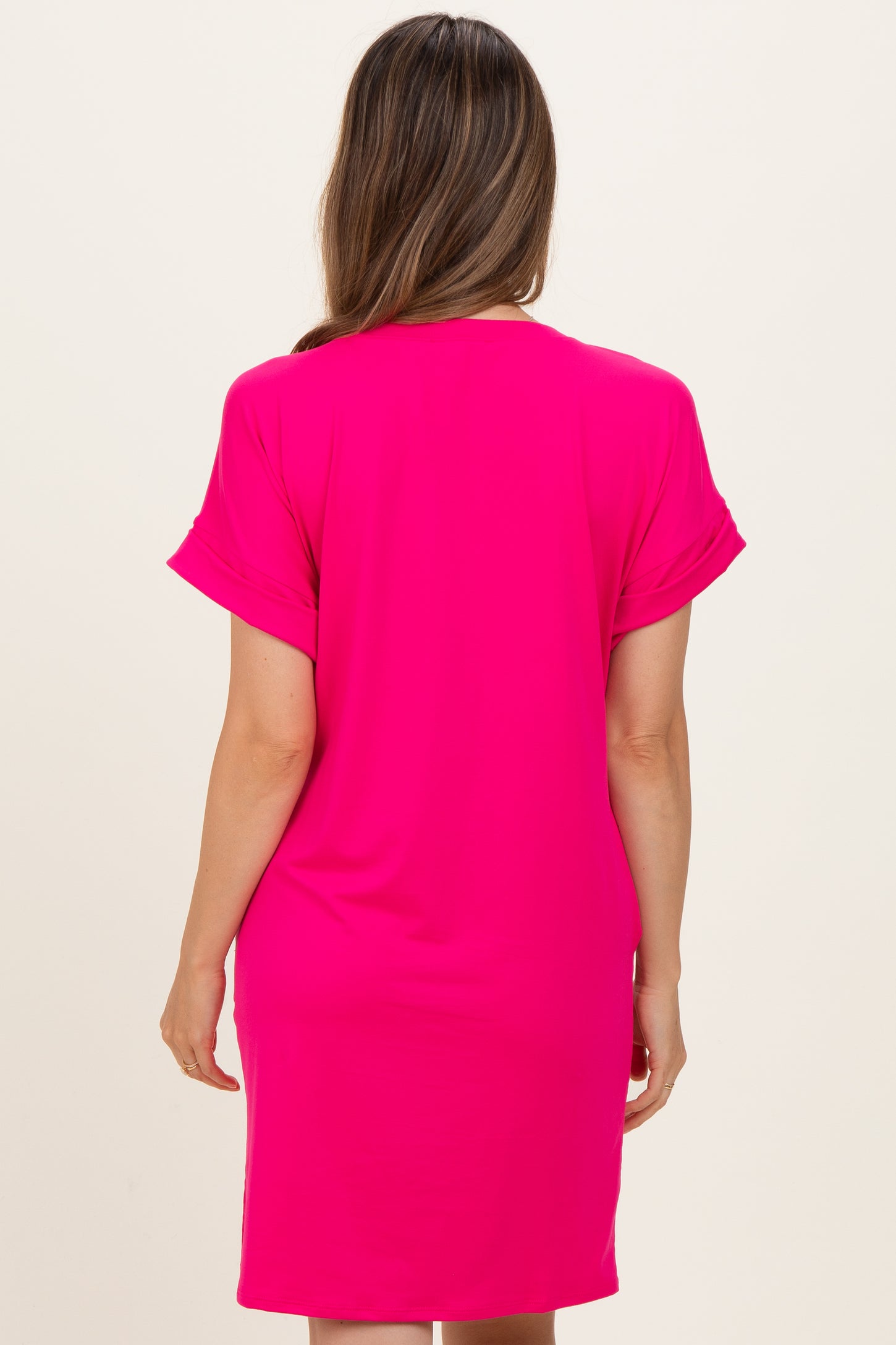 woman wearing a bright pink maternity dress with short sleeves, shown from the back