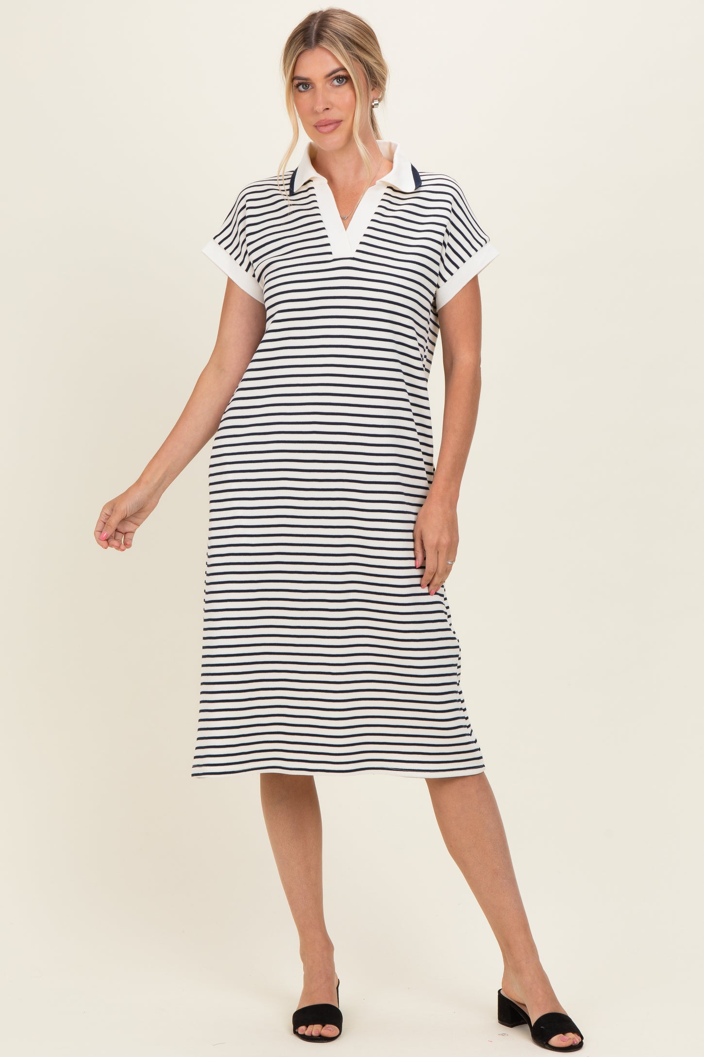 woman wearing a navy and white striped midi dress with a collared neckline and short sleeves