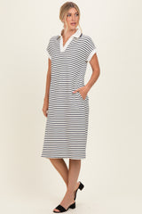 woman wearing a black and white striped polo dress with short sleeves and pockets