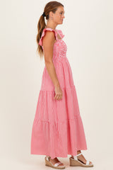 woman wearing a red and white gingham maxi dress with ruffle straps and a tiered skirt, paired with wedge sandals