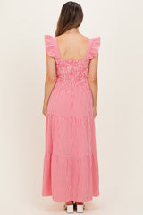 woman wearing a flowy pink and white gingham maxi dress with ruffled sleeves and a tiered hemline