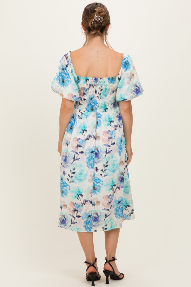 woman wearing a floral maternity dress with puff sleeves and a smocked back, showing a baby bump from the side