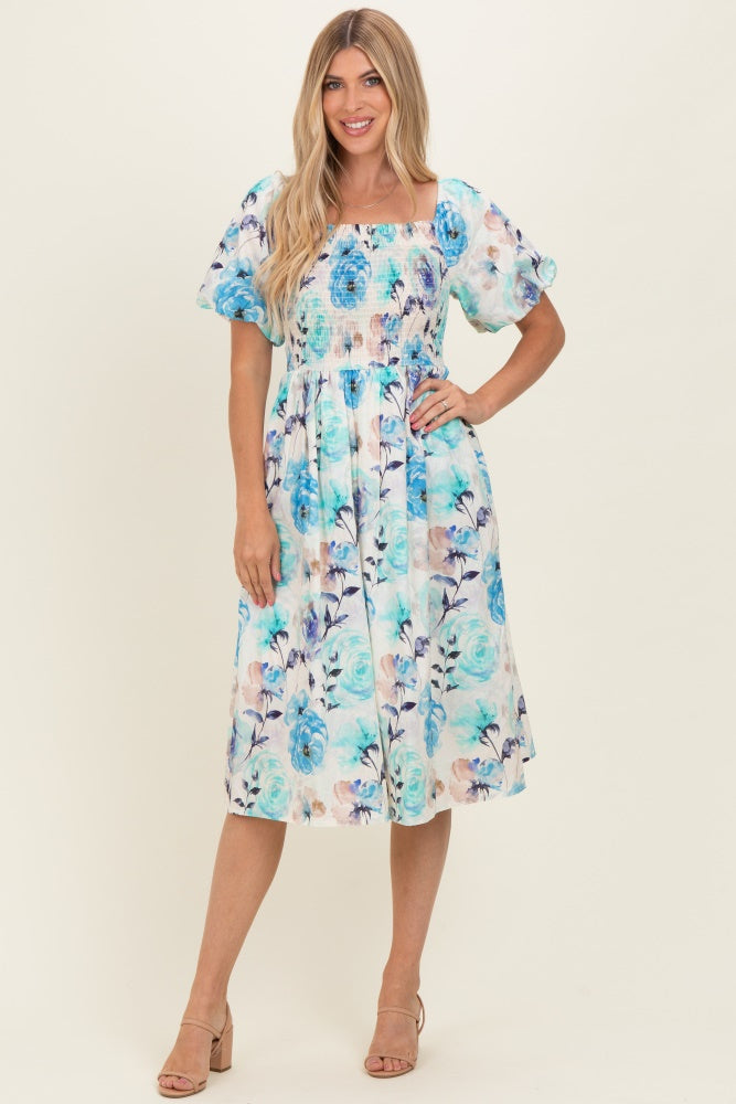 woman wearing a floral print midi dress with puff sleeves in blue and white