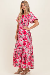 woman wearing a pink floral maxi dress with puff sleeves and a smocked bodice