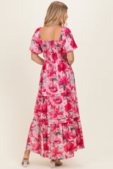woman wearing a pink floral maxi dress with short puff sleeves and tiered skirt, shown from the back