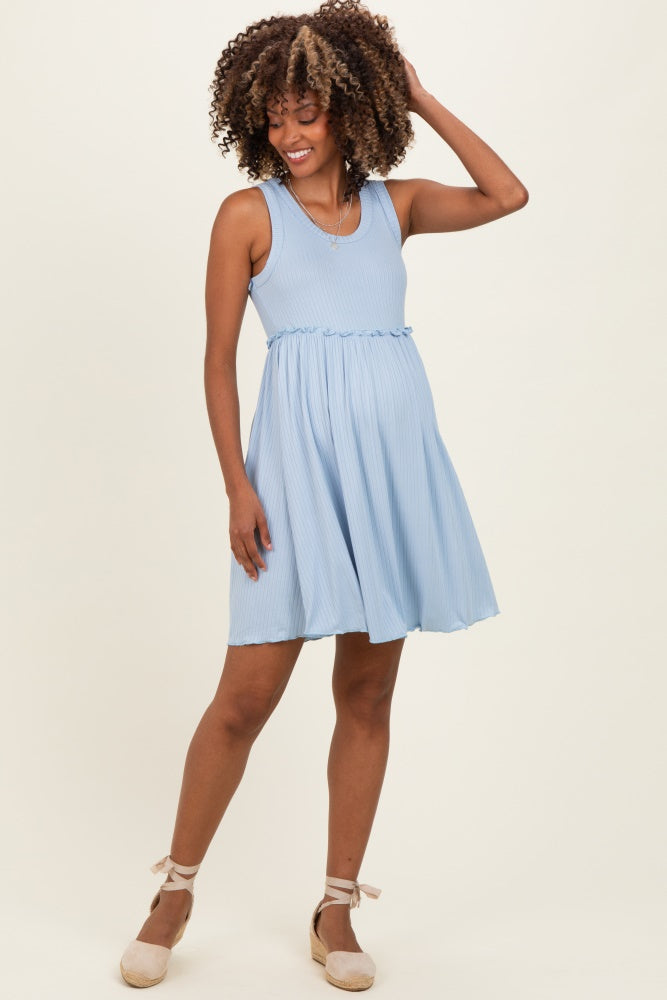 woman wearing a light blue maternity dress with a fitted bodice and flared skirt, showing her baby bump