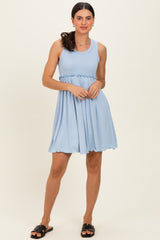 woman wearing a light blue sleeveless dress with a fitted bodice and flared skirt