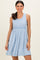 woman wearing a light blue sleeveless dress with a ruffled waist and flared skirt