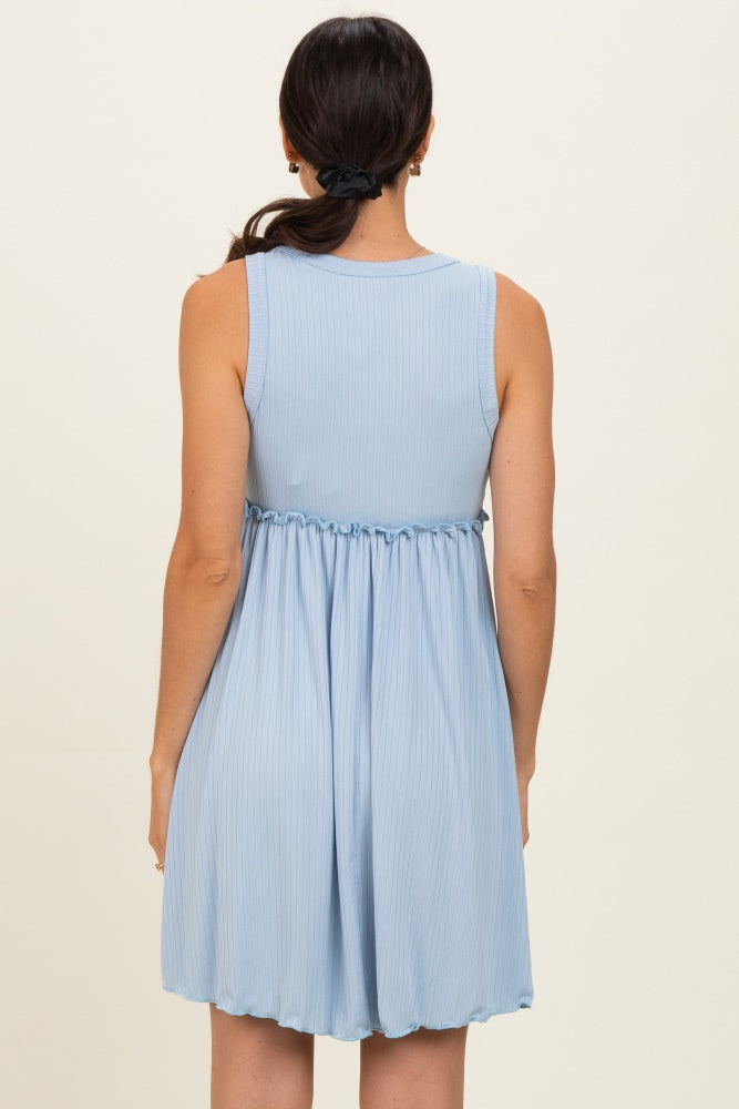 woman wearing a light blue sleeveless tiered dress with a gathered waist and back pleats