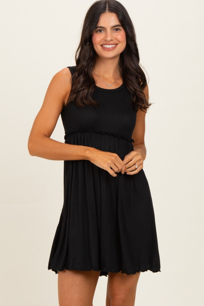 woman wearing a black sleeveless ribbed mini dress with a fitted bodice and loose skirt