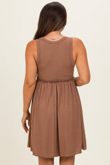 woman wearing a brown sleeveless maternity dress with a pleated design and an elastic waistband