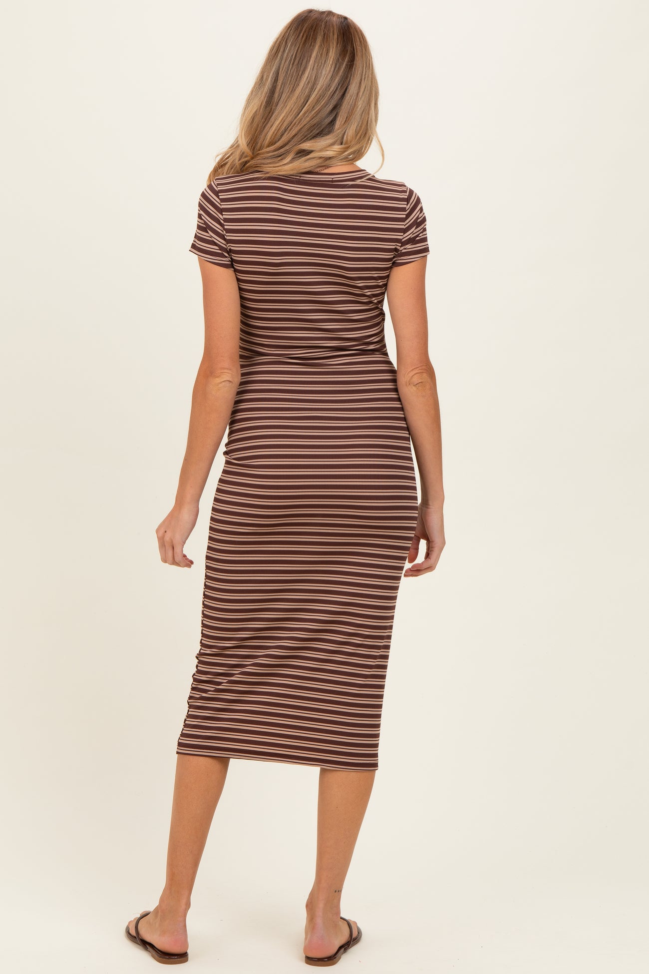 woman wearing a striped brown maternity dress with short sleeves and a fitted silhouette, seen from the back