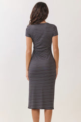 woman wearing a fitted black and white striped midi dress with short sleeves and a ruched back detail