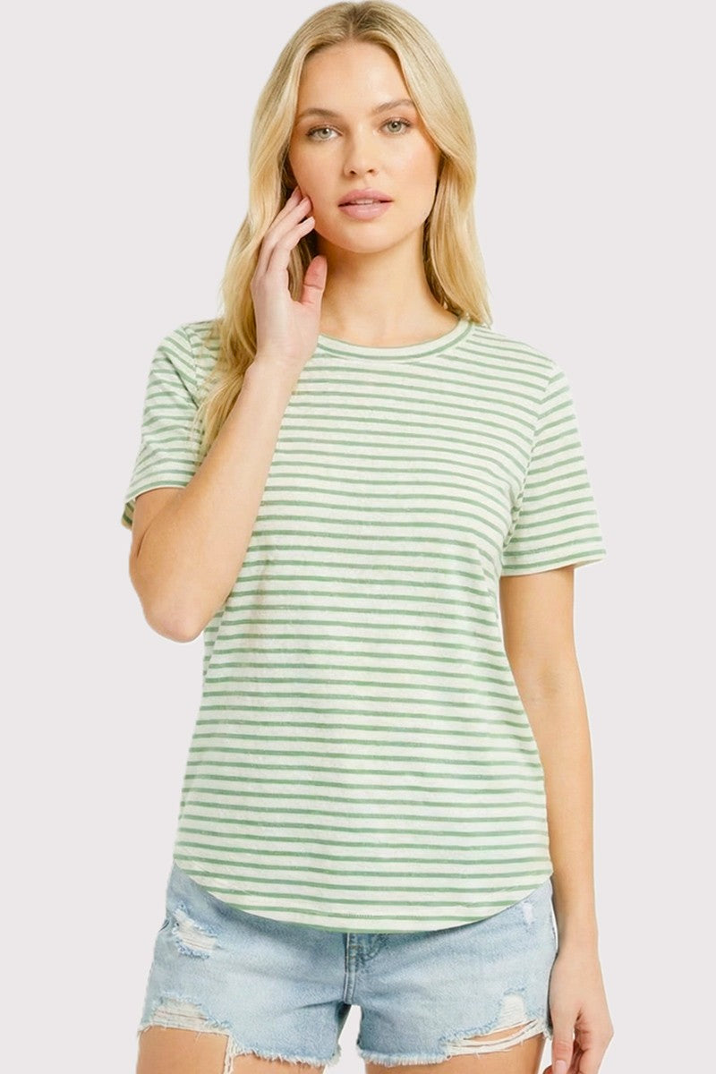 woman wearing a green and white striped short sleeve t-shirt with a relaxed fit and distressed denim shorts