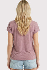woman wearing a dusty rose short sleeve t-shirt with rolled sleeves, paired with light denim shorts from the back