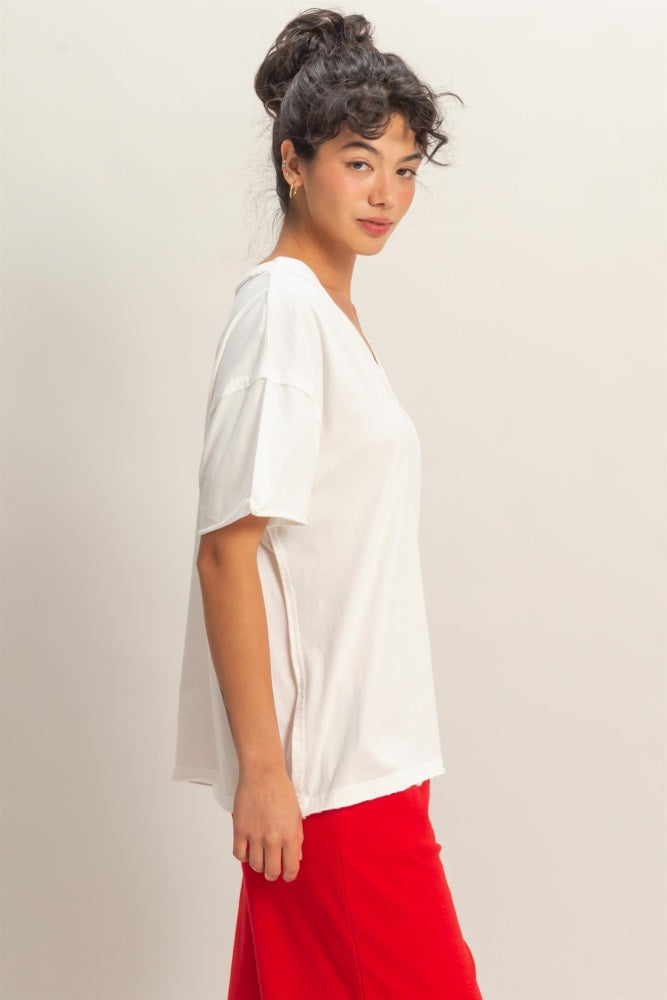 woman wearing a white short sleeve v-neck top paired with a red skirt