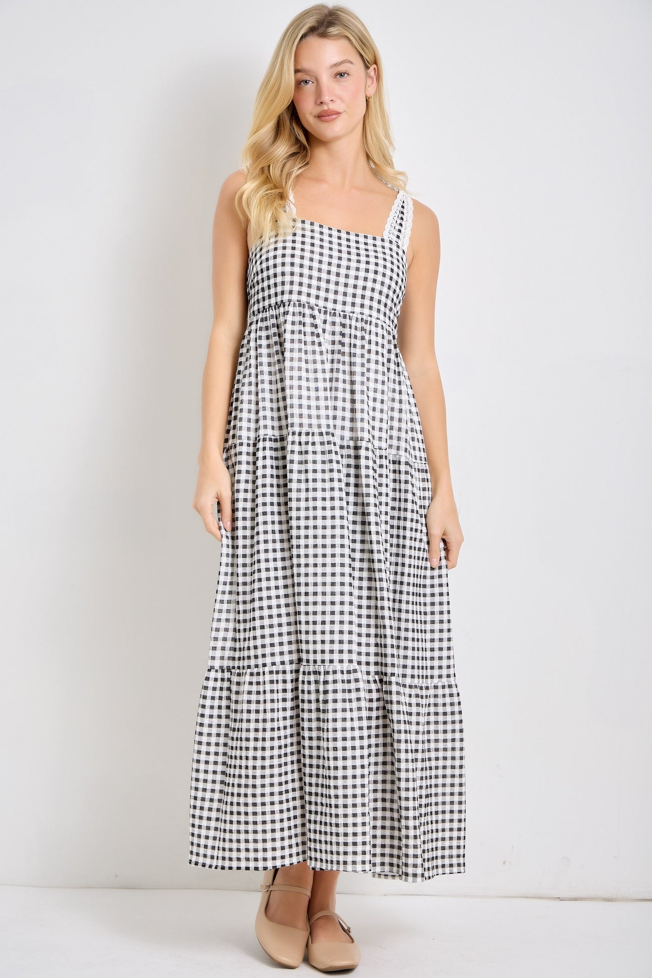 woman wearing a black and white checkered maxi dress with tiered ruffles and thin straps