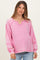 woman wearing a pink long sleeve maternity top with scoop neckline and contrast stitching, showing her baby bump