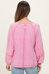 woman wearing a pink maternity long sleeve top with stitched detailing and balloon sleeves, viewed from the back