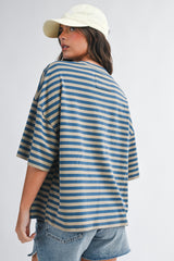 woman wearing a loose-fitting blue and beige striped oversized t-shirt with a round neckline and short sleeves