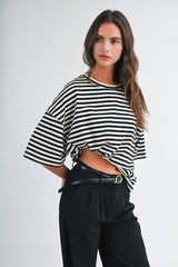 woman wearing a black and white striped oversized t-shirt with high-waisted black trousers