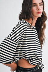 woman wearing a black and white striped oversized tee with short sleeves and a knotted front detail