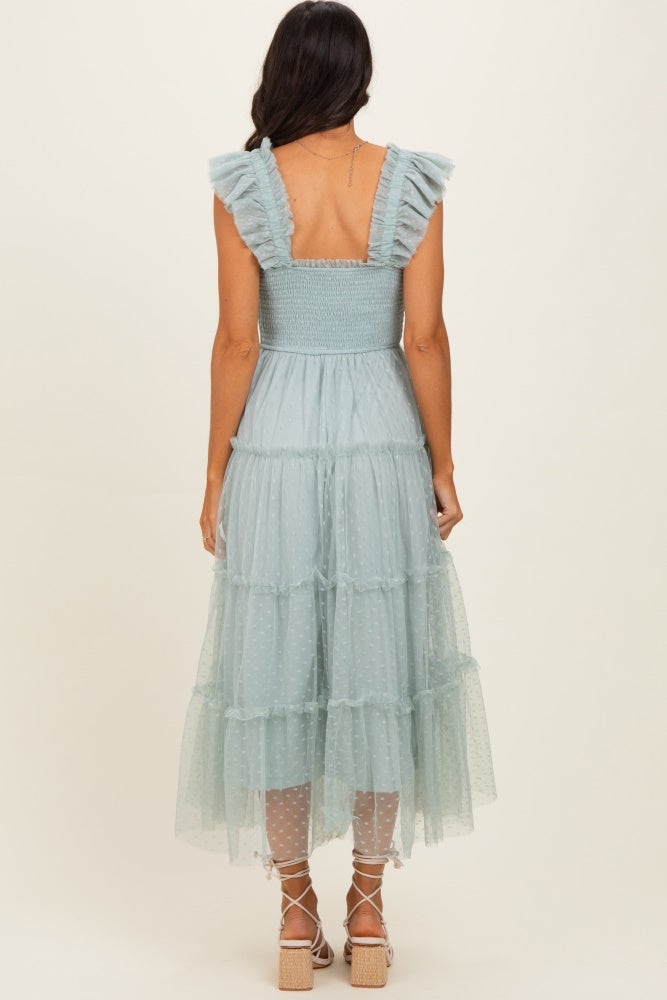 woman wearing a light blue tiered midi dress with ruffled straps and a smocked bodice, viewed from the back