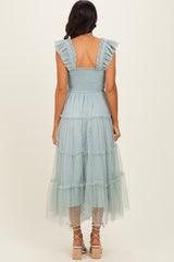 woman wearing a light blue tiered midi dress with ruffled straps and a smocked bodice, viewed from the back