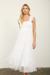 woman wearing a white tiered midi dress with ruffled straps and a smocked bodice