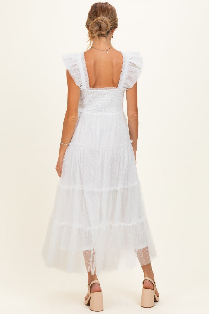woman wearing a white tiered maternity dress with ruffle straps and a smocked bodice, seen from the back