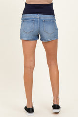 woman wearing light wash maternity shorts, showing a comfortable waistband, viewed from the back