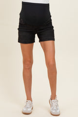 woman wearing black maternity denim shorts with a stretchy black belly panel and white sneakers