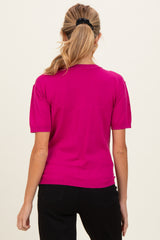 woman wearing a bright pink short sleeve maternity top, viewed from the back