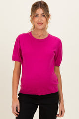 woman wearing a bright pink short sleeve maternity top with a relaxed fit and visible baby bump