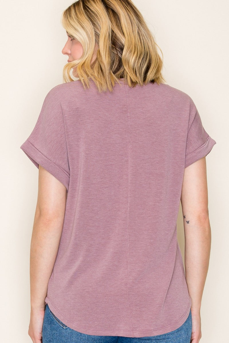 woman wearing a mauve short sleeve top with rolled cuffs, viewed from the back