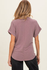 woman wearing a dusty rose short sleeve maternity top with rolled sleeves and a relaxed fit, viewed from the back