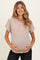 woman wearing a dusty pink maternity top and holding her baby bump with a smile